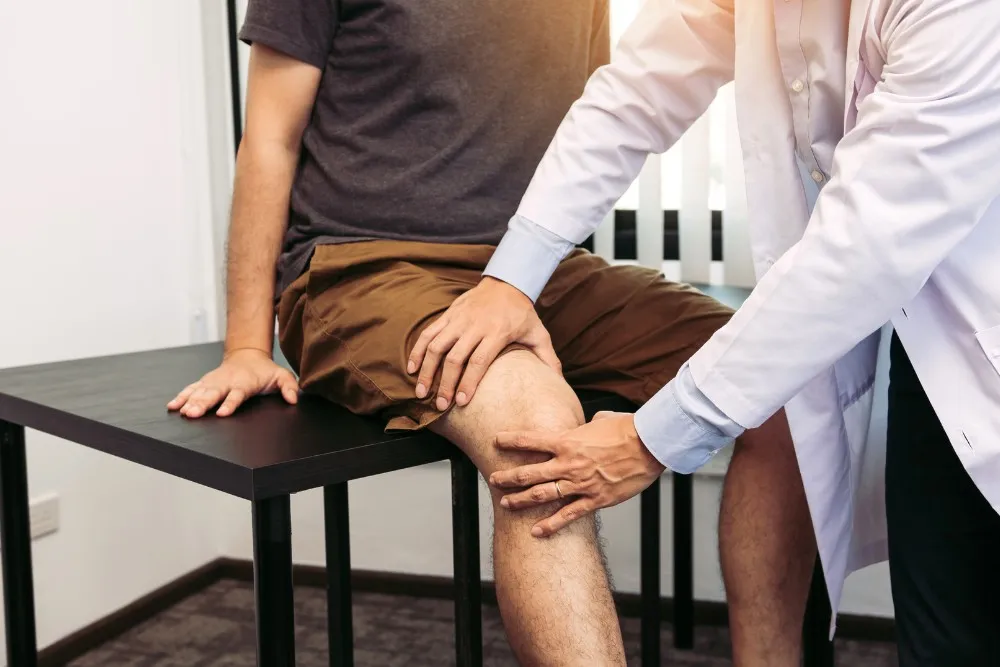 Physiotherapist working through a knee exercise with a patient during treatment