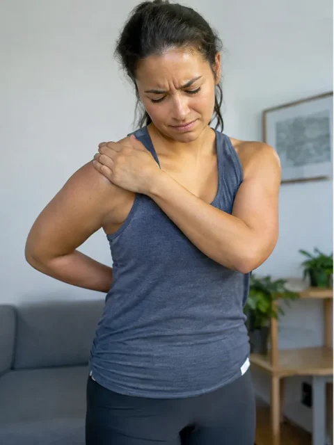 Woman gripping a painful shoulder