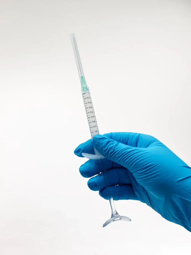 Clinician holding a pre-filled Arthrosamid syringe, ready for injection